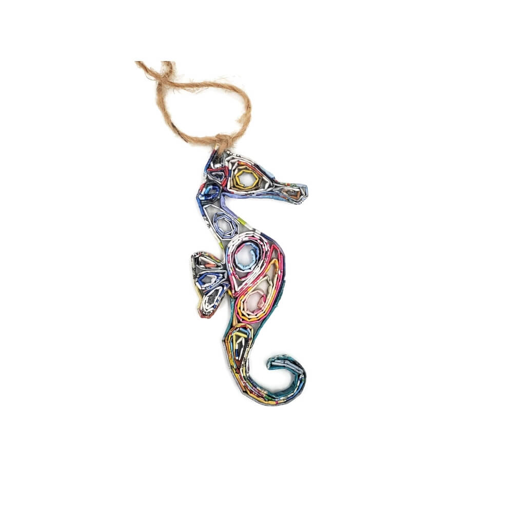 A hanging paper ornament made from brightly colored recycled folded magazine paper and coiled into the shape of a seahorse.