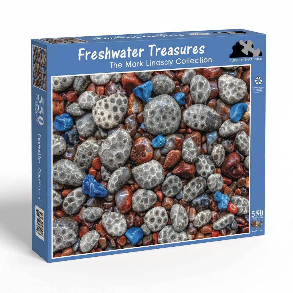 Jigsaw puzzle box featuring a Petoskey stones, Leland Blue, and Agates. The blue box says 'Freshwater Treasures' and 'The Mark Lindsay Collection' in text.