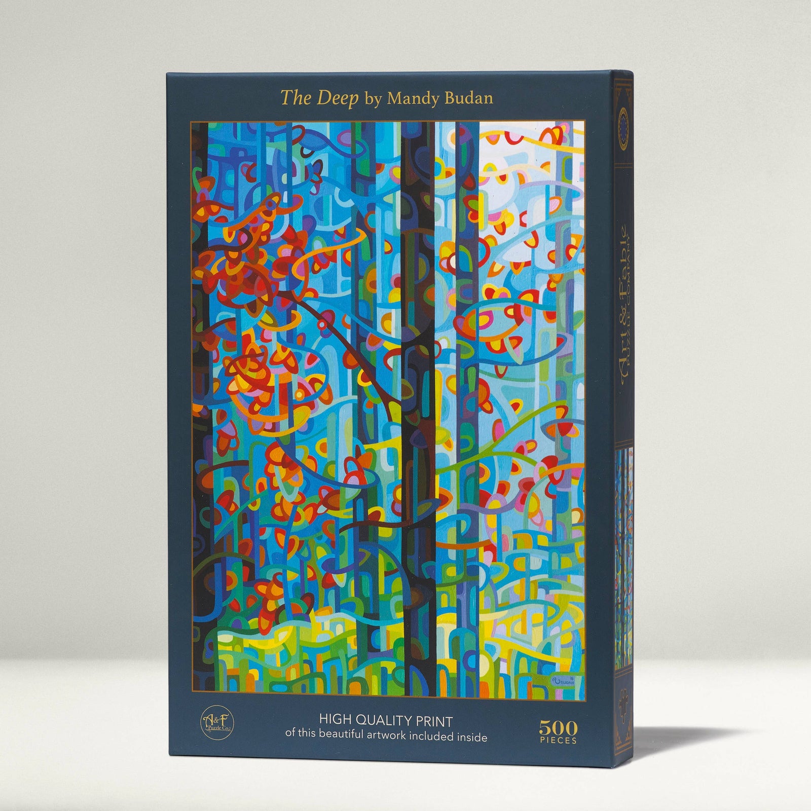Jigsaw puzzle box with colorful abstract design and 'The Deep' by Mandy Budan text on a white background