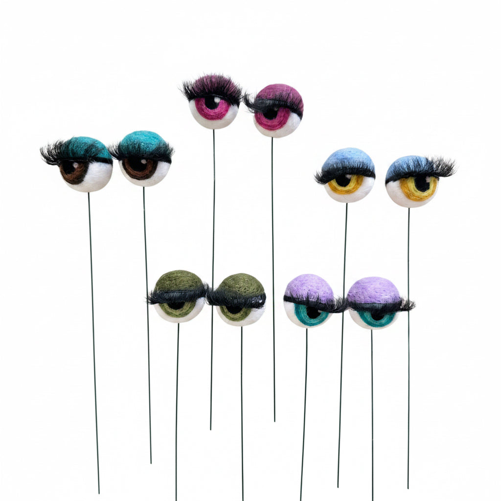 Colorful felted eyes with eyelashes on a white background