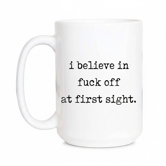 White mug with black text 'i believe in fuck off at first sight' on a white background
