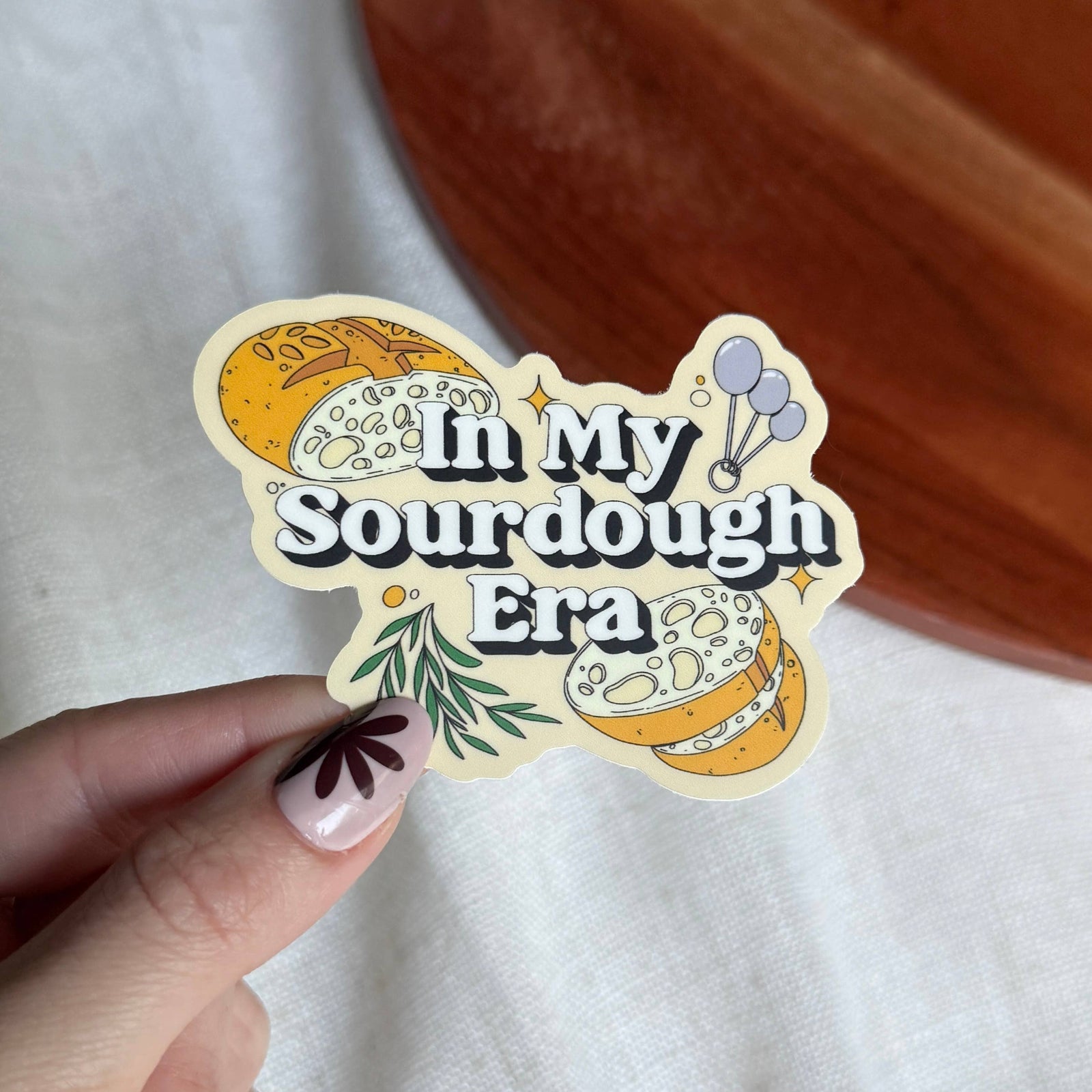 Sticker with 'In My Sourdough Era' text held by a hand on a white background