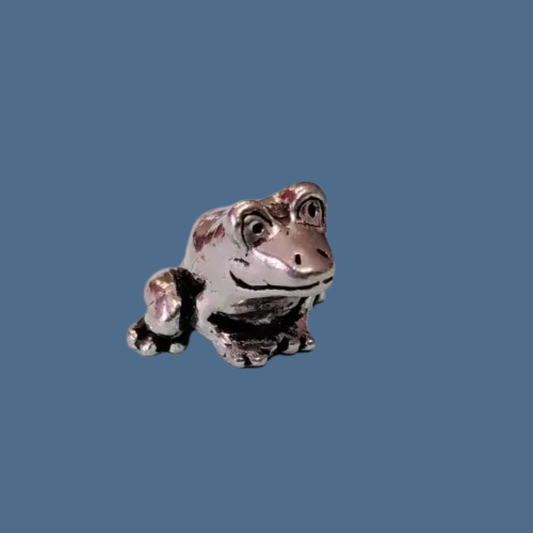 Metallic frog figurine on a blue background