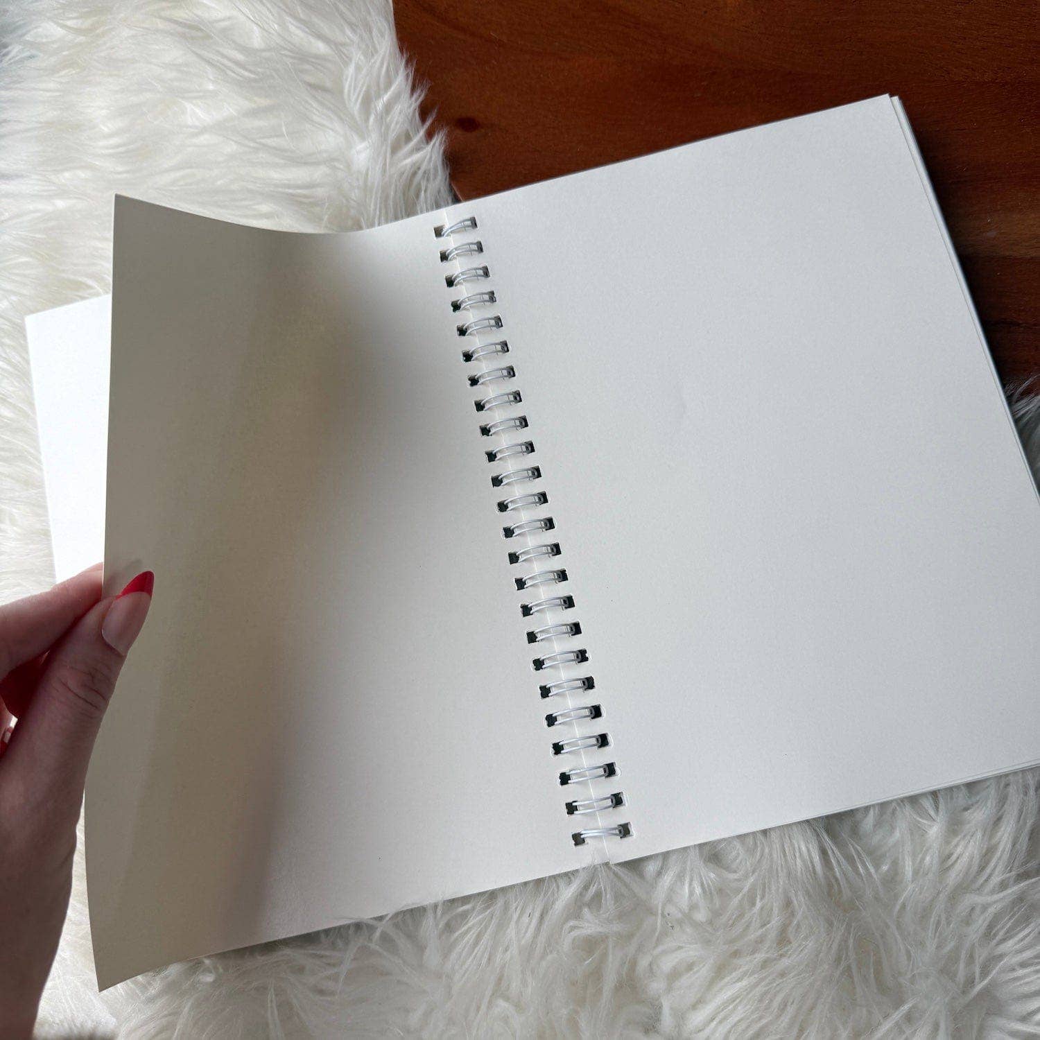 Open notebook with white pages on a fluffy white surface
