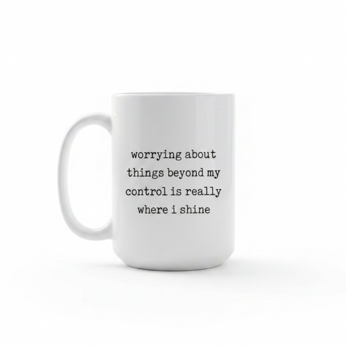 White mug with black text 'worrying about things beyond my control is really where i shine' in a kitchen on a wooden table.