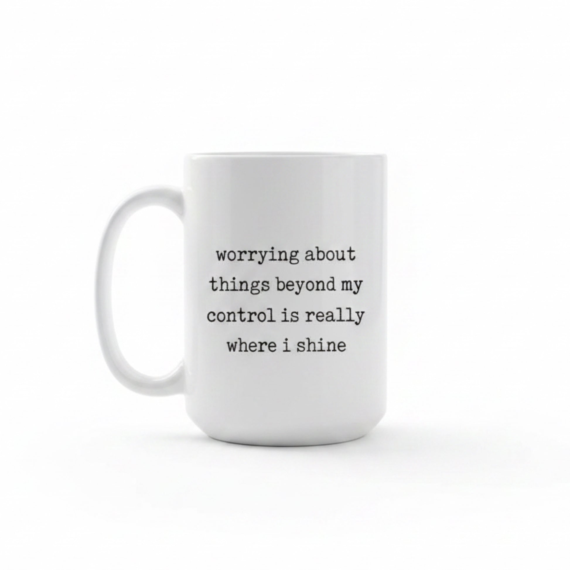 White mug with black text 'worrying about things beyond my control is really where i shine' in a kitchen on a wooden table.