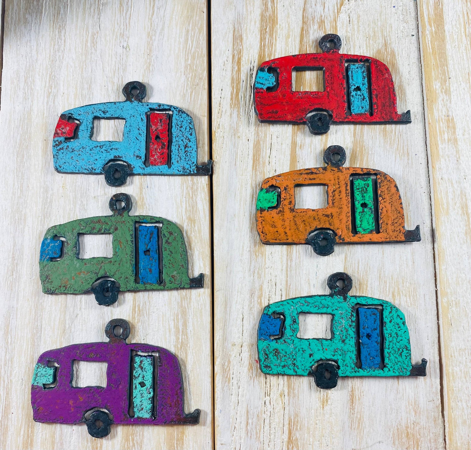 Brightly painted camper trailers with black wheel and hitch. Black metal loop at the top for use as ornament, pendant or charm.