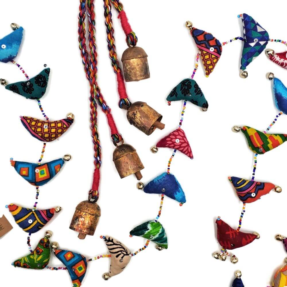 Song Bird Garland made of recycled sari fabric, seed beads, and small bells.  A second product featuring 4 large bells on brightly colored braided cord is also pictured..