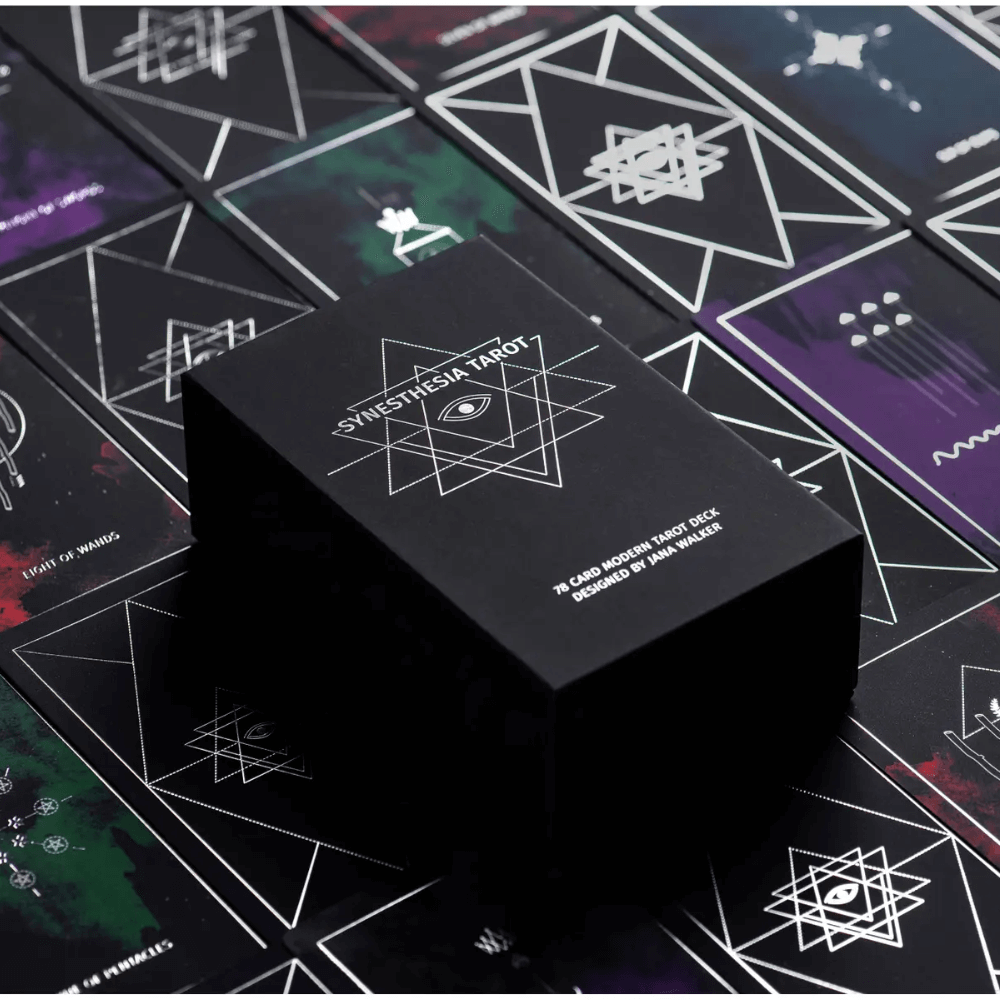 Modern minimalist Synesthesia Tarot deck with clean line art cards in a black box with silver geometric graphics.