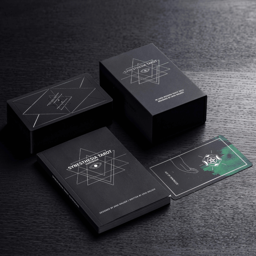 Modern minimalist Synesthesia Tarot deck with clean line art cards in a black box with silver geometric graphics.